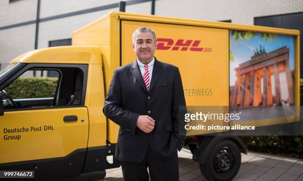 Juergen Gerdes, a member of the board of directors of the German Post DHL Group, in front of an emission-free post van during a press conference...