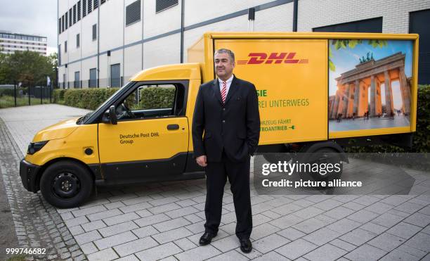 Juergen Gerdes, a member of the board of directors of the German Post DHL Group, in front of an emission-free post van during a press conference...