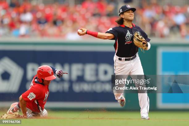 Bo Bichette of Team USA throws to first base as Luis Urias of the World Team is out at second in a fourth-inning double play during the SiriusXM...