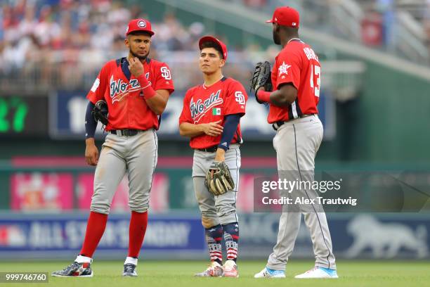 Fernando Tatis Jr. #23, Luis Urias and Yordan Alvarez of the World Team look on during the SiriusXM All-Star Futures Game at Nationals Park on...