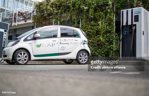 An electric car is parked at a charging station on the grounds of the Fraunhofer Institute of Labor Economics and Organization in Stuttgart, Germany,...