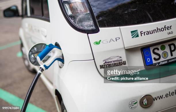 An electric car is charged on the grounds of the Fraunhofer Institute of Labor Economics and Organization in Stuttgart, Germany, 4 September 2017....