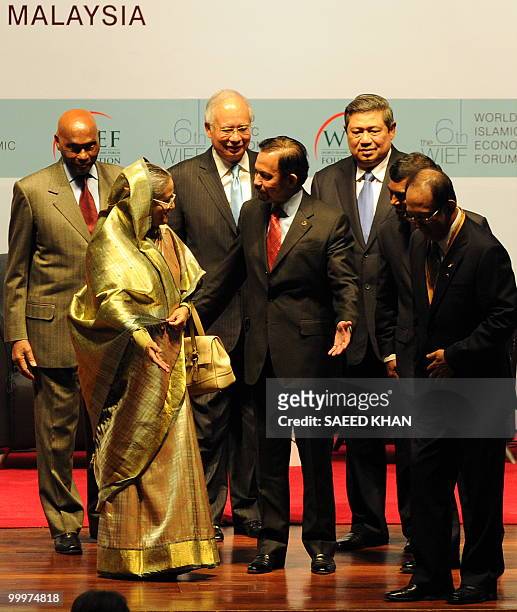 Brunei's Sultan Hassanal Bolkiah offers Bangladesh's Prime Minister Sheikh Hasina to proceed first along with other leaders at the end of the opening...