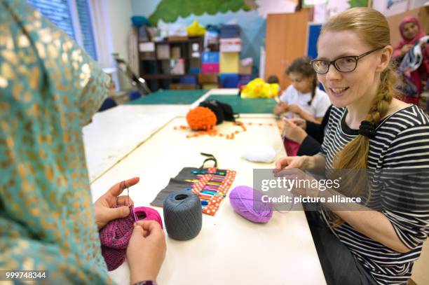 Kati Hyyppaei from Finland sits next to a refugee woman from Afghanistan in the room of a refugee home in Berlin, Germany, 6 September 2017. Hyyppaei...