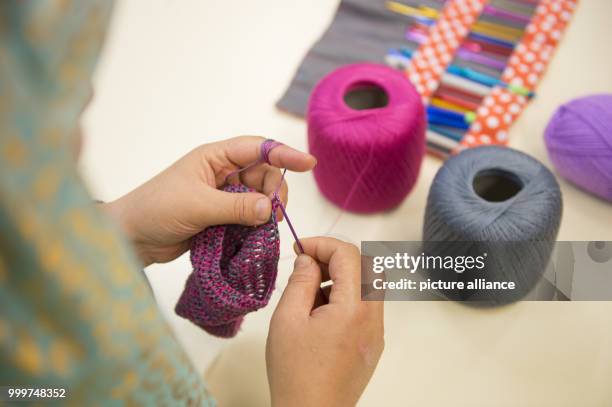 Refugee woman from Afghanistan participates in a sewing course organised by Kati Hyyppaei from Finalnd in the room of a refugee home in Berlin,...