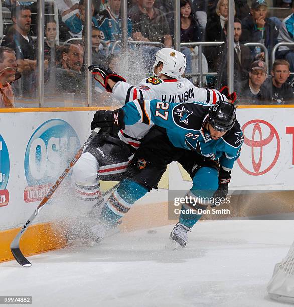 Niklas Hjalmarsson of the Chicago Blackhawks is checked into the boards by Manny Malhotra of the San Jose Sharks in Game Two of the Western...