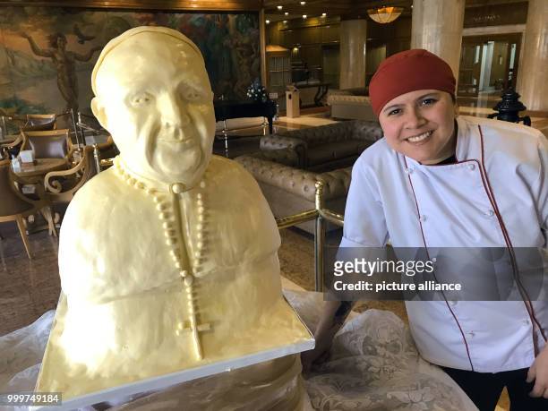 Natalia Galvis of the confectionary team of the Hotel Tequendama poses next to the pope bust made of margarine which she created with three...