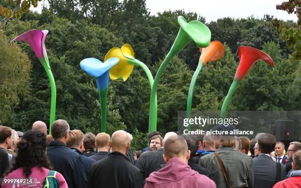 People participate in the inauguration of the monument made up of giant colourful calla lilies at the Magnus-Hirschfeld-Ufer in Berlin, Germany, 7...