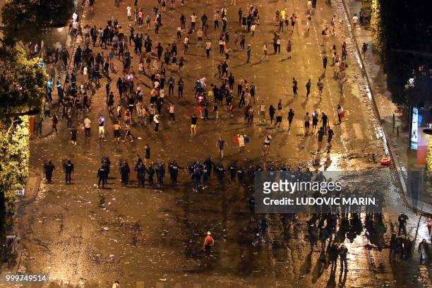 This picture taken from the top of the Arch of Triumph on July 15, 2018 shows security forces working to contain clashes following celebrations of...