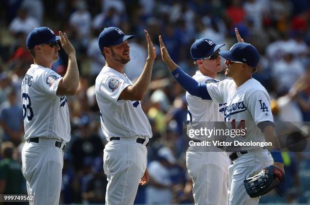 Ross Stripling, Rich Hill, Chase Utley and Enrique 'Kike' Hernandez of the Los Angeles Dodgers celebrate with high-fives after the MLB game against...