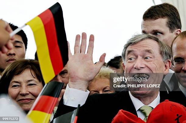 German President Horst Koehler and his wife Eva Luise are greeted by children waving German flags at the site of the World Expo 2010 in Shanghai on...