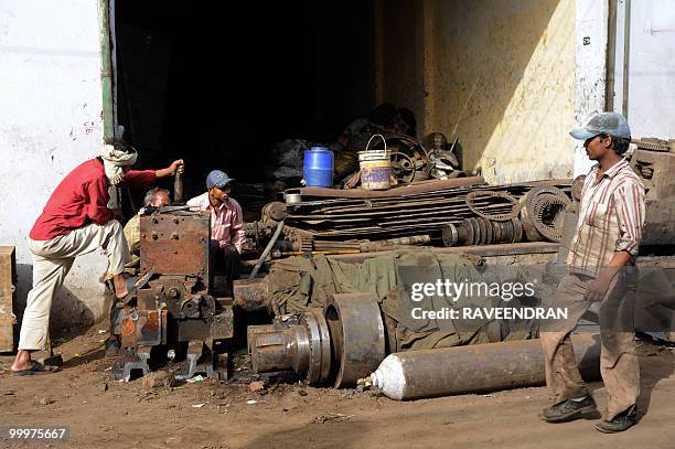 Indian labourers work in front of a scrap metal shop at the Mayapuri scrap market in New Delhi on May 19, 2010. India's atomic energy regulator said...
