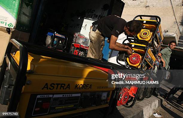Palestinian man inspects a generator displayed outside his shop in Gaza City on May 6, 2010. In war-scarred Gaza, generators are the latest killer,...