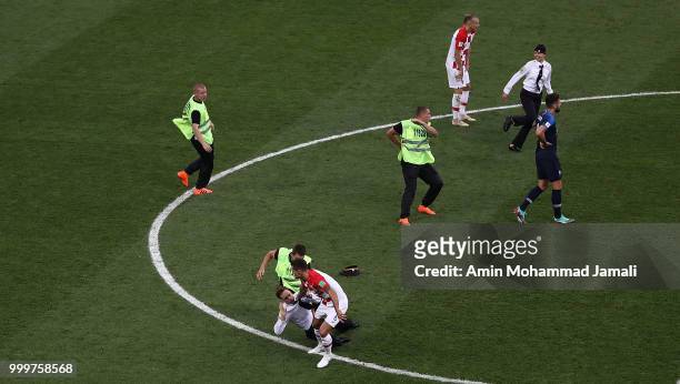 Security guards remove a protester from the pitch during the 2018 FIFA World Cup Russia Final between France and Croatia at Luzhniki Stadium on July...