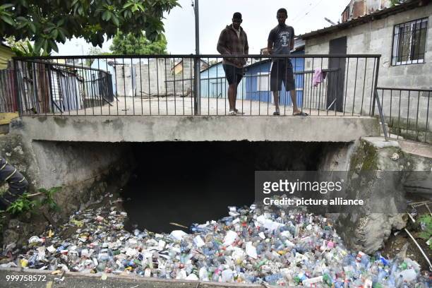 Two men look at plastic bottles that have piled up under a bridge after hurricane 'Irma' has passed the city of Santo Domingo, Dominican Republic, 7...