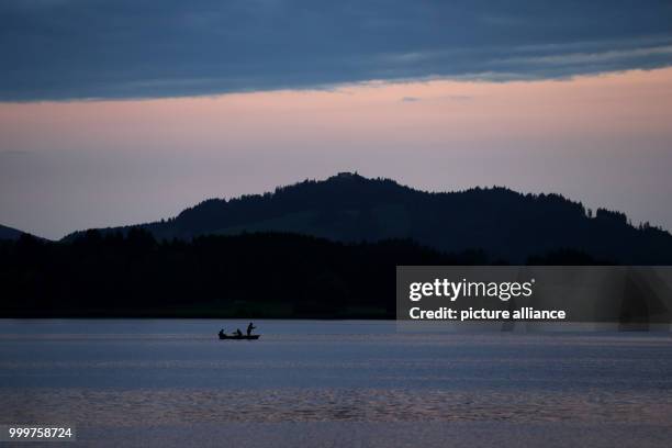 Fishers on a boat at Hopfensee lake at sundown, near Fuessen, Germany, 7 September 2017. Photo: Karl-Josef Hildenbrand/dpa