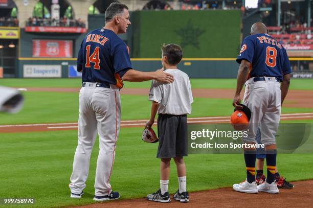 Houston Astros manager A.J. Hinch lines up for the National Anthem with a young ball player before the baseball game between the Detroit Tigers and...