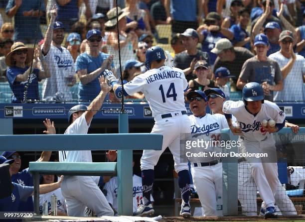 Enrique 'Kike' Hernandez of the Los Angeles Dodgers is congratulated by manager Dave Roberts as Hernandez enters the dugout after hitting a solo...
