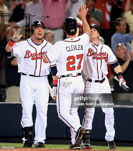 Brent Clevlen of the Atlanta Braves is congratulated by Eric Hinske and Nate McLouth after scoring the game-winning run against the New York Mets at...