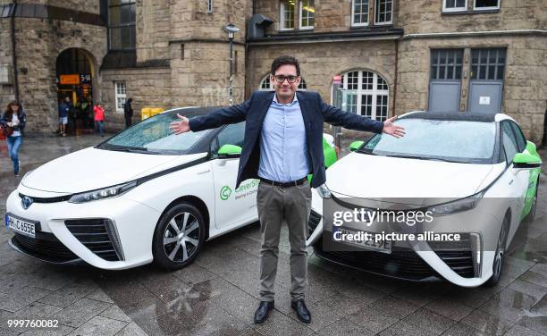 Bruno Ginnuth, chairman and co-founder of the ridesharing provider Clever Shuttle, powered by hydrogen, can be seen posing in front of two Toyota...