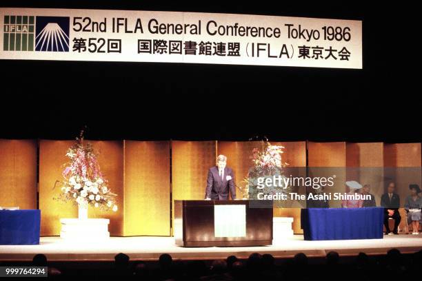 Crown Prince Akihito addresses while Crown Princess Michiko listens during the 52nd International Federation of Library Associations and Institutions...