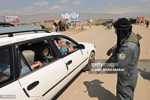 An Afghan policeman searches a car on a road leading to the US air base in Bagram, 50 kms north of Kabul, on May 19, 2010. Taliban militants armed...