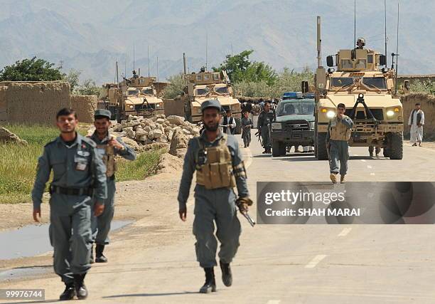 Soldiers and Afghan policemen stand guard on a road leading to the US air base in Bagram, 50 kms north of Kabul, on May 19, 2010. Taliban militants...