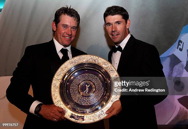 Lee Westwood of England is presented with the Players' Player Award by Padraig Harrington of Ireland during the 2010 Tour Dinner prior to the BMW PGA...