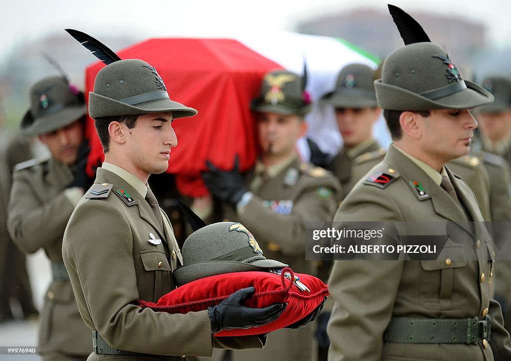 A comrade carries the hat of one of the