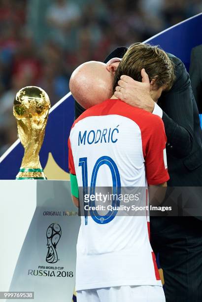 President Gianni Infantino embraces Luka Modric of Croatia during the trophy presentation at the end of the 2018 FIFA World Cup Russia Final between...