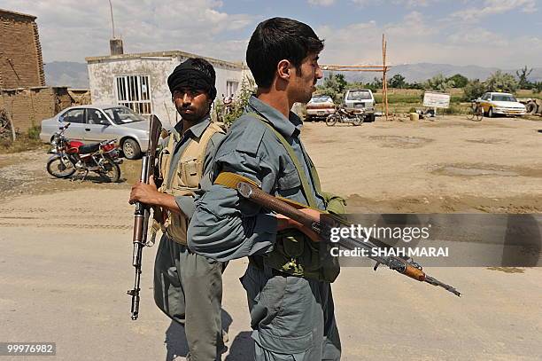 Afghan policemen stand guard on a road leading to the US air base in Bagram, 50 kms north of Kabul, on May 19, 2010. Taliban militants armed with...