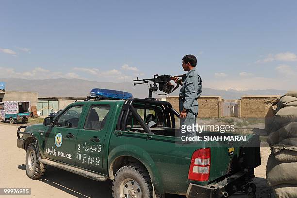 An Afghan policeman keeps watch on a road leading to the US air base in Bagram, 50 kms north of Kabul, on May 19, 2010. Taliban militants armed with...