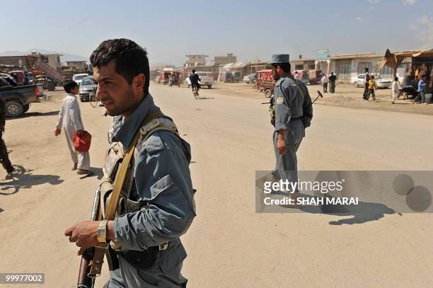 Afghan policemen keep watch on a road leading to the US air base in Bagram, 50 kms north of Kabul, on May 19, 2010. Taliban militants armed with...