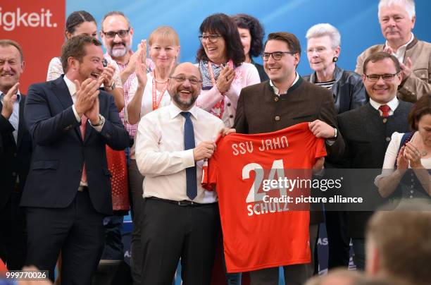 Candidate for Chancellor Martin Schulz holds up a soccer jersey of 2nd Bundesliga club Jahn Regensburg at an election campaign event in Regensburg,...