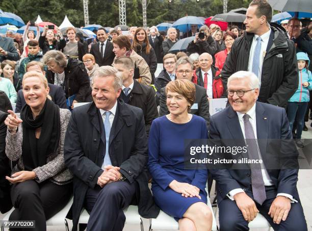 German president Frank-Walter Steinmeier and his wife Elke Buedenbender sit next to former President Christian Wulff and his wife Bettina during the...