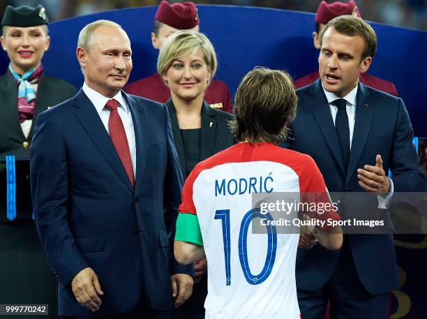 French President Emmanuel Macron embraces Luka Modric of Croatia as Russian President Vladimir Putin looks on after the 2018 FIFA World Cup Russia...