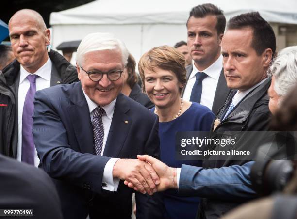 German president Frank-Walter Steinmeier and his wife Elke Buedenbender shake hands of guests of the citizen festival at the Bellevue Palace in...