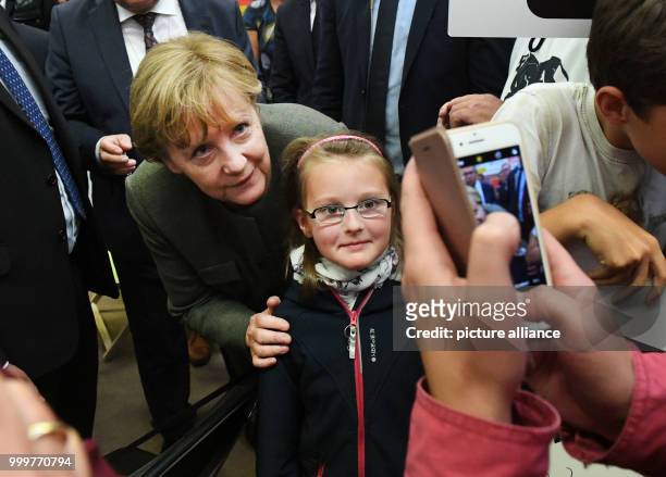 German Chancellor Angela Merkel poses for a picture with a young boy during a CDU election campaign event in Wolgast, Germany, 08 September 2017....