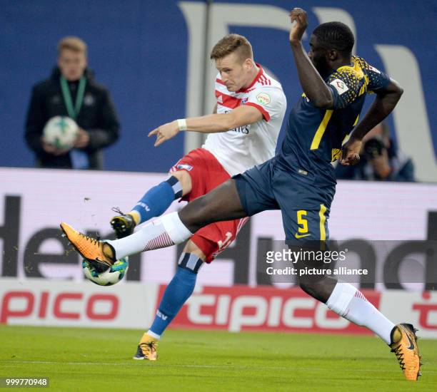 Hamburg's Andre Hahn and Leipzig's Dayot Upamecano vie for the ball during the Bundesliga soccer match between Hamburg SV and RB Leipzig in the...