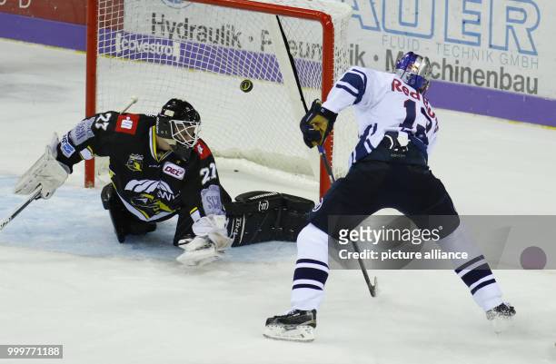Munich's Michael Wolf shoots the 2:3 goal via penalty against Krefeld's Michel Weidekamp during the icehockey first league game between Krefeld...