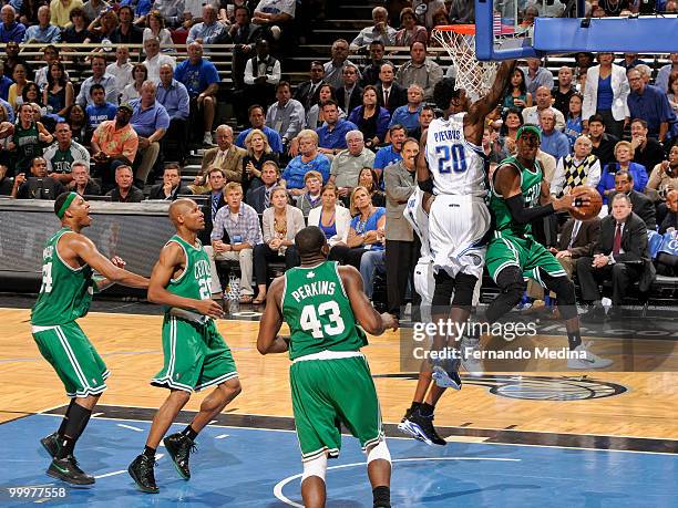 Rajon Rondo of the Boston Celtics takes the ball to the basket drawing Mickael Pietrus of the Orlando Magic to defend leaving Kendrick Perkins, Ray...