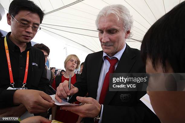 Former German football player Rudi Voeller, who is now manager of Bayer 04 Leverkusen, signs for fans while visiting the World Expo Park at the...