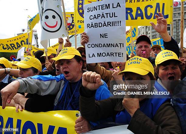 Romanian Trade Union members shout anti-governmental slogans as one displays a banner which translates as We are out of patience, don't condemn us to...