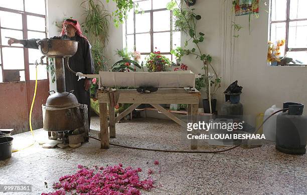 Syrian villager prepares rose water from locally-grown Damascus roses using a traditional method in the Syrian village of al-Mrah, 60 kms north of...