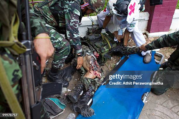 Thai security forces attempt to help a Thai soldier hit by a grenade on May 19, 2010 in Bangkok, Thailand. At least 5 people are reported to have...