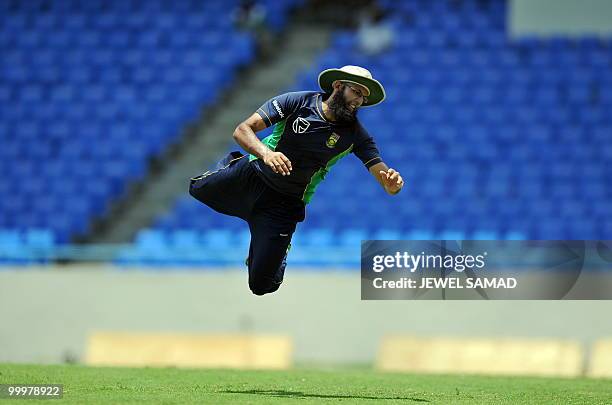 South African cricketer Hashim Amla jumps to catch the ball during a practice session at the Sir Vivian Richards Stadium in St John's on May 18,...