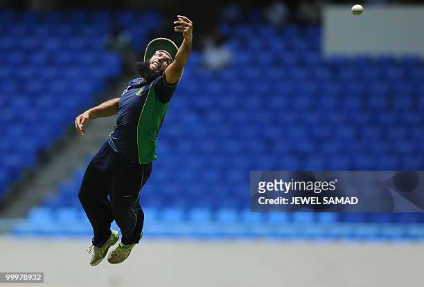South African cricketer Hashim Amla jumps to catch the ball during a practice session at the Sir Vivian Richards Stadium in St John's on May 18,...