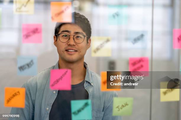 asian business man brainstorming at a creative office - portrait of pensive young businessman wearing glasses stock pictures, royalty-free photos & images