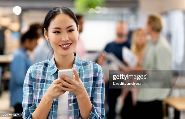 femme réfléchie affaires asiatiques utilisant app sur son téléphone cellulaire au bureau - ���������������������������������������������������������������app���������zg357cc��������������������������������������������������������������� photos et images de collection