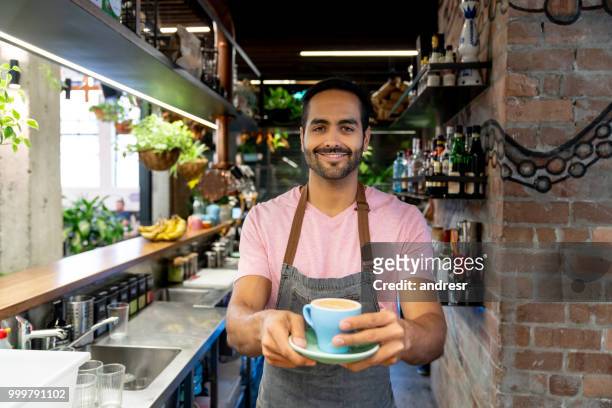 barista che serve caffè in un bar - man eating at diner counter foto e immagini stock